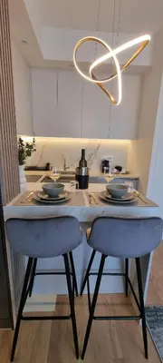 a kitchen with a table with two chairs and a chandelier at Beograd na vodi - BW Terra Exclusive in Belgrade