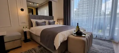a bedroom with a large bed with a bottle of wine at Beograd na vodi - BW Terra Exclusive in Belgrade