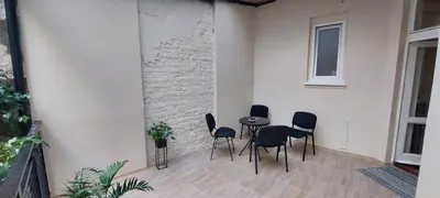 a patio with chairs and a table and a wall at Bohemian in Belgrade