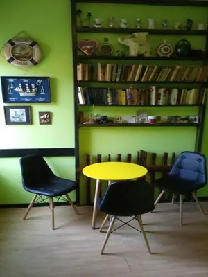 a table and chairs in a room with a book shelf at Hostel Ruler in Belgrade