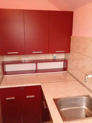 a kitchen with brown cabinets and a sink at Hostel Ruler in Belgrade