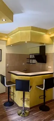 a kitchen with two bar stools and a counter at Hostel Ruler in Belgrade