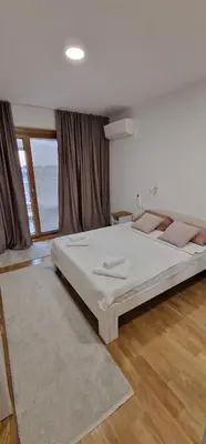 a bedroom with a large bed and a large window at Oaza 45 in Belgrade