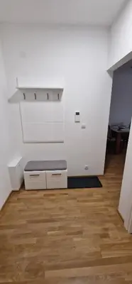 a white room with a bench on a wooden floor at Oaza 45 in Belgrade