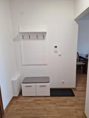a white room with a bench on a wooden floor at Oaza 45 in Belgrade