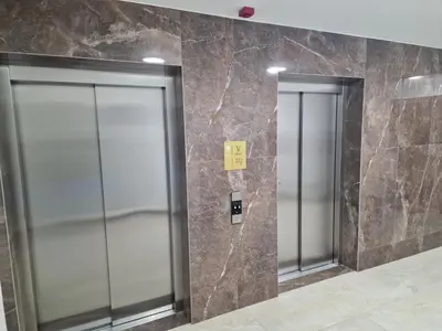 two elevator doors in a building with marble walls at Oaza 45 in Belgrade