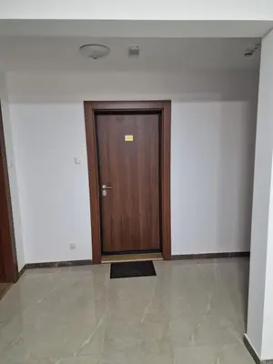 a hallway with a wooden door and a tile floor at Oaza 45 in Belgrade