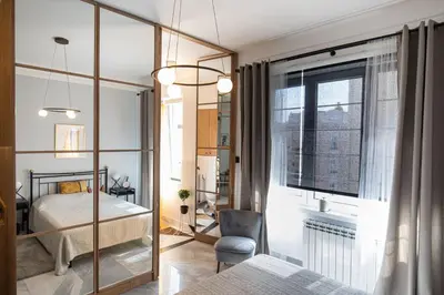 a bedroom with a bed and a chair and a window at City Centre Elegance: Kosancicev Venac Studio in Belgrade