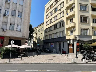 a city street with buildings and tables and umbrellas at City Centre Elegance: Kosancicev Venac Studio in Belgrade