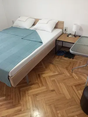 a bedroom with a bed and a desk with a laptop at Airport MD rooms in Belgrade