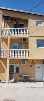 a building with two chairs and a table in front of it at Airport MD rooms in Belgrade
