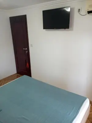 a bedroom with a bed with a flat screen tv on the wall at Airport MD rooms in Belgrade