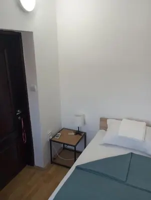 a bedroom with a bed and a table with a lamp at Airport MD rooms in Belgrade
