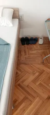 a pair of shoes sitting on a floor next to a bed at Airport MD rooms in Belgrade