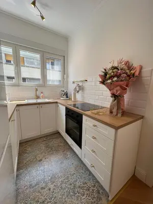a kitchen with white cabinets and a vase of flowers at Old Town Gate in Belgrade