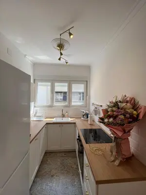a kitchen with white cabinets and a vase of flowers on the counter at Old Town Gate in Belgrade