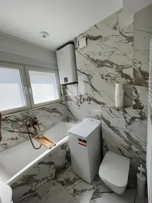 a bathroom with a toilet and a marble wall at Old Town Gate in Belgrade