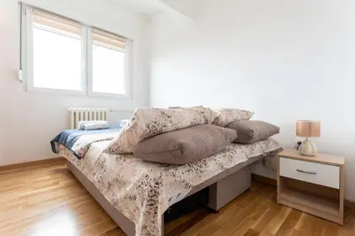 a bedroom with a bed with pillows on it at Aurora Apartman in Belgrade