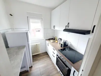 a small kitchen with white cabinets and a sink at Aurora Apartman in Belgrade