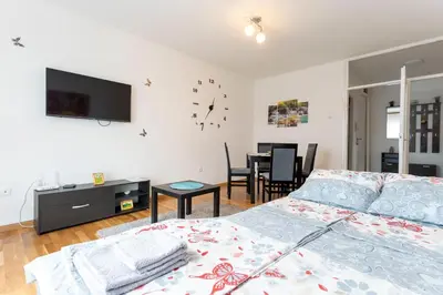 a bedroom with a bed and a tv on the wall at Aurora Apartman in Belgrade