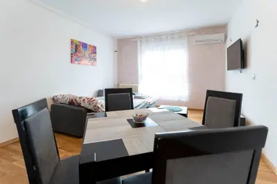 a dining room with a table and chairs at Aurora Apartman in Belgrade