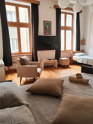a bedroom with a large bed and a living room at Republic Square Studio in Belgrade