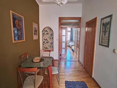 a dining room with a table and chairs and a hallway at Republic Square Studio in Belgrade