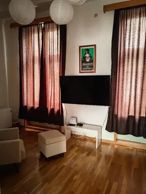 a living room with red curtains and a flat screen tv at Republic Square Studio in Belgrade