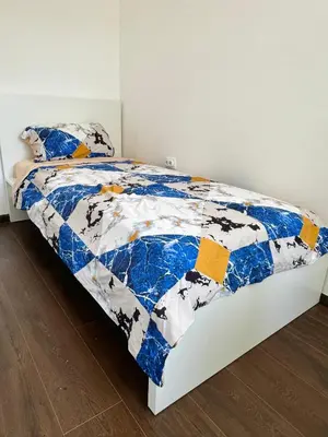 a bedroom with a bed with a blue and white quilt at Lux Flat Center in Belgrade