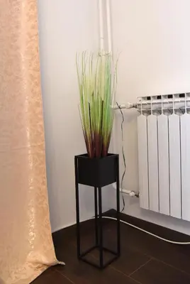 a black stool with a plant on top of it at Lux Flat Center in Belgrade