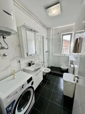 a white bathroom with a sink and a washing machine at Lux Flat Center in Belgrade