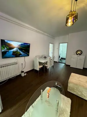 a living room with a table and a tv on the wall at Lux Flat Center in Belgrade