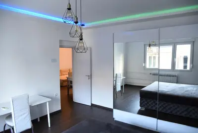 a bedroom with a bed and a desk and a table at Lux Flat Center in Belgrade