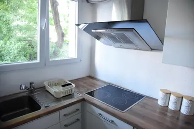 a kitchen with a stove and a sink and a window at Lux Flat Center in Belgrade