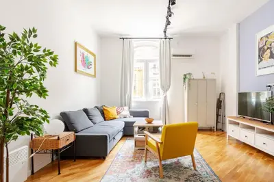 a living room with a couch and a tv at Artika - Chic & Sunlit Stay in Downtown Belgrade in Belgrade