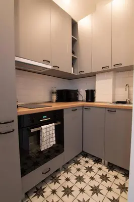 a kitchen with white cabinets and a black oven at Artika - Chic & Sunlit Stay in Downtown Belgrade in Belgrade