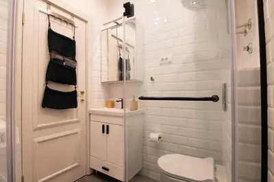 a white bathroom with a toilet and a shower at Artika - Chic & Sunlit Stay in Downtown Belgrade in Belgrade