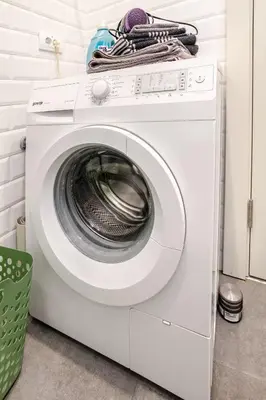 a white washing machine sitting in a laundry room at Artika - Chic & Sunlit Stay in Downtown Belgrade in Belgrade