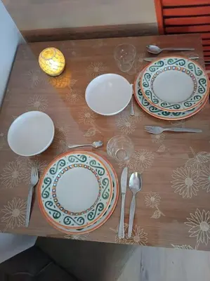 a wooden table with plates and silverware on it at Bohemian Lux Apartment Skadarlija in Belgrade