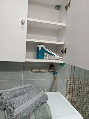 a bathroom with a toilet and a towel on a shelf at Bohemian Lux Apartment Skadarlija in Belgrade