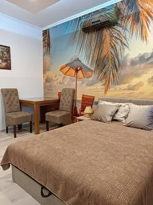 a bedroom with a bed and a desk with a palm tree mural at Bohemian Lux Apartment Skadarlija in Belgrade