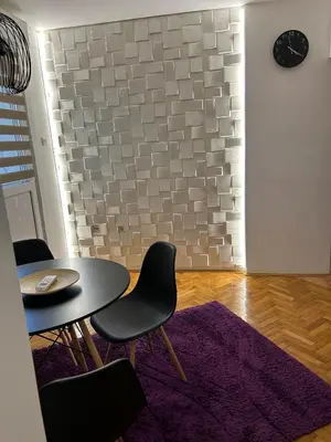 a dining room with a table and chairs and a brick wall at Martina Lux in Belgrade