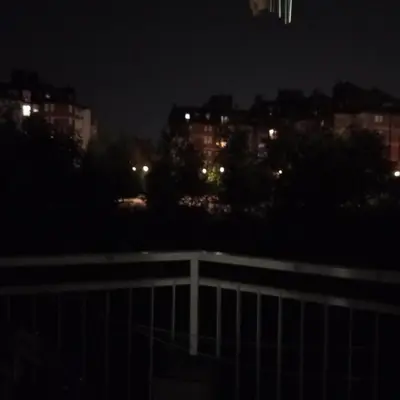 a view of a city at night with a fence at Apartment MrCvetko FREE PARKING in Bežanija