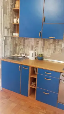 a blue kitchen with a sink and blue cabinets at Apartment MrCvetko FREE PARKING in Bežanija