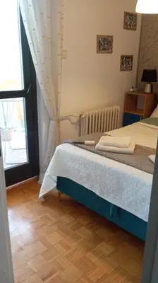 a bedroom with a bed and a window at Apartment MrCvetko FREE PARKING in Bežanija