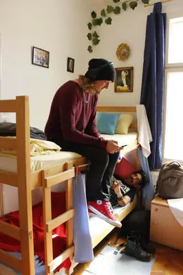 a woman sitting on top of a bunk bed at Hostel El Diablo in Belgrade