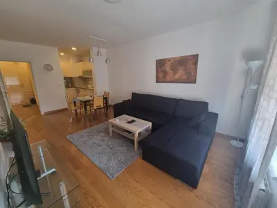 a living room with a black couch and a table at Grand Residence in Bežanija