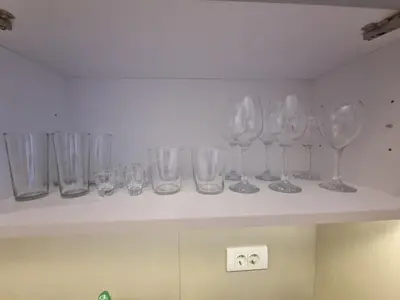 a row of wine glasses sitting on a shelf at Grand Residence in Bežanija