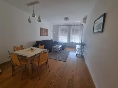 a dining room and living room with a table and chairs at Grand Residence in Bežanija