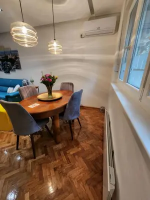 a dining room with a wooden table and chairs at Nancy's Cozy Business Apartment in Bežanija